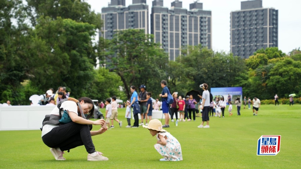 為慶祝香港特區成立26周年，香港哥爾夫球會昨日舉辦同樂日活動，開放粉嶺舊球場，讓市民可悠閒散步及參加康體活動，吸引過萬人前來參與。市民在綠油油的草地上悠閒散步拍照。資料圖片