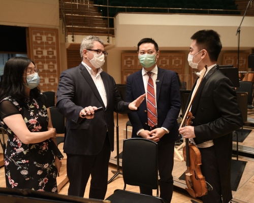 徐英偉(右二)聽取霍品達(左二)介紹樂團的工作。政府新聞處圖片