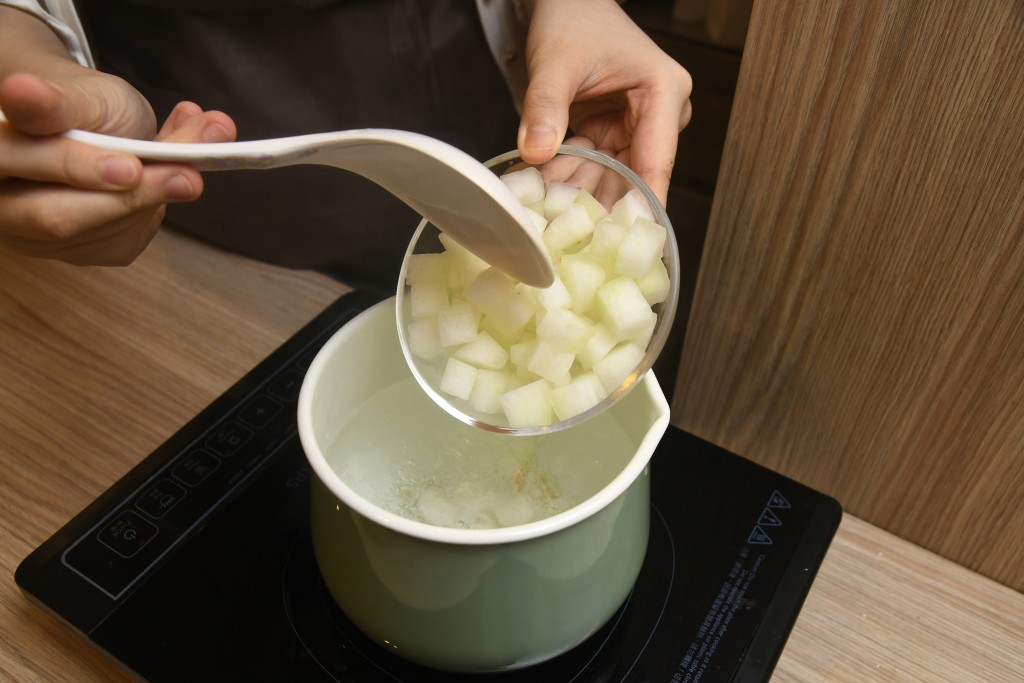 Step 6: 將冬瓜、蝦仁、帶子、百 合、薑、清雞湯及水放入煲內，煲二十分鐘。Put the winter melon, shrimps, scallops, lily bulb, ginger, chicken broth and water into a pot, boil for 20 minutes.