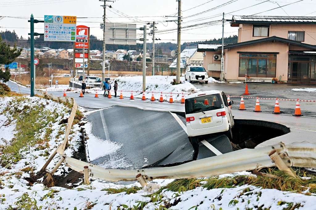 青森縣震後道路塌陷，一輛汽車險跌入洞內。