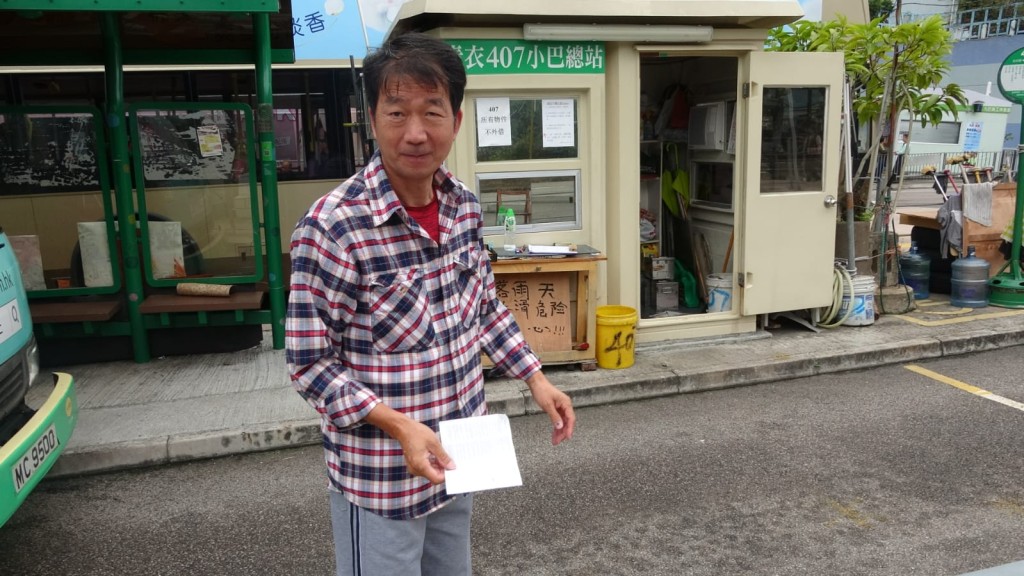 一名小巴司機向記者展示多張警方發出的違例泊車告票。 林思明攝