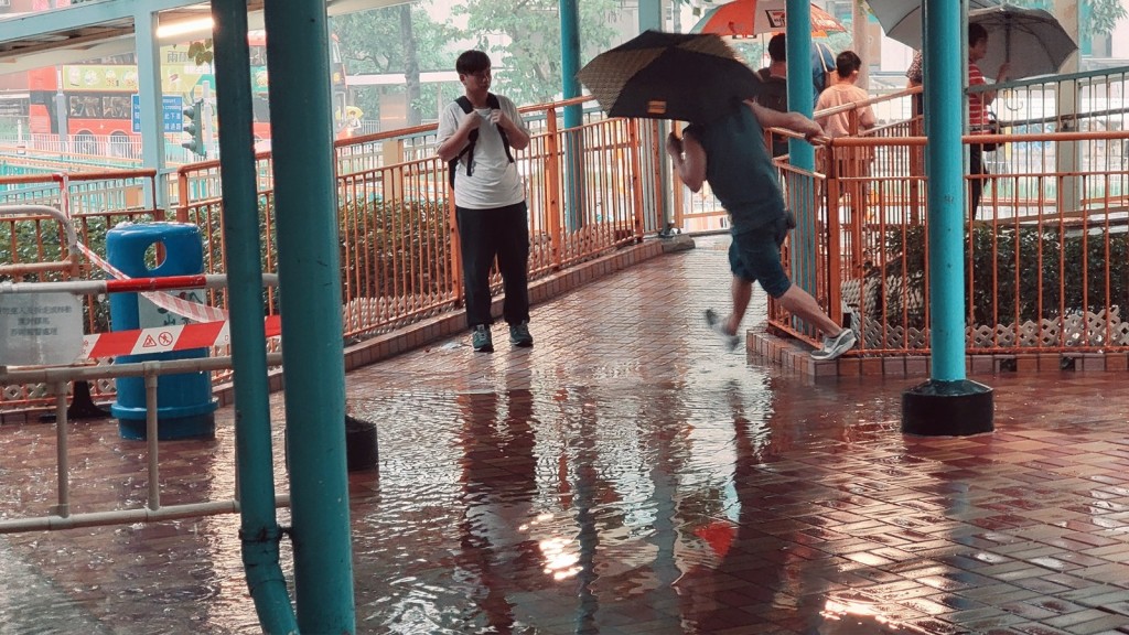 屯门出现水浸情况，有巿民更直接跳过水浸地方。网络图片