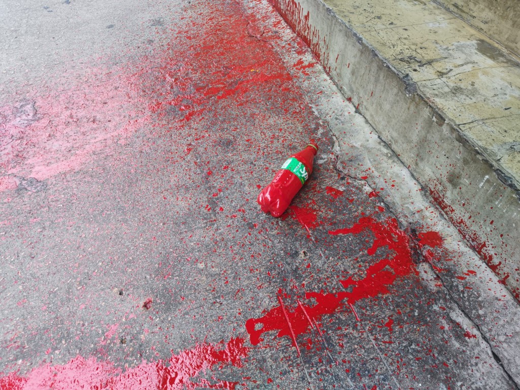 地上遺下一個裝載有紅油的膠樽。梁國峰攝