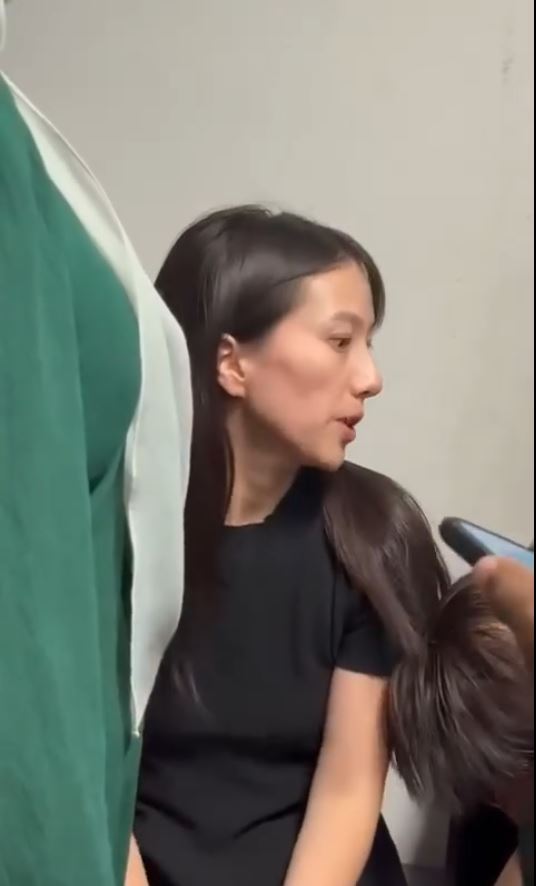 涉嫌殴打大马移民官的中国女游客被锁上手扣。Threads＠rizalhakimm_punyer