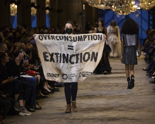 示威者手舉「overconsumption = extinction」。美聯社圖片
