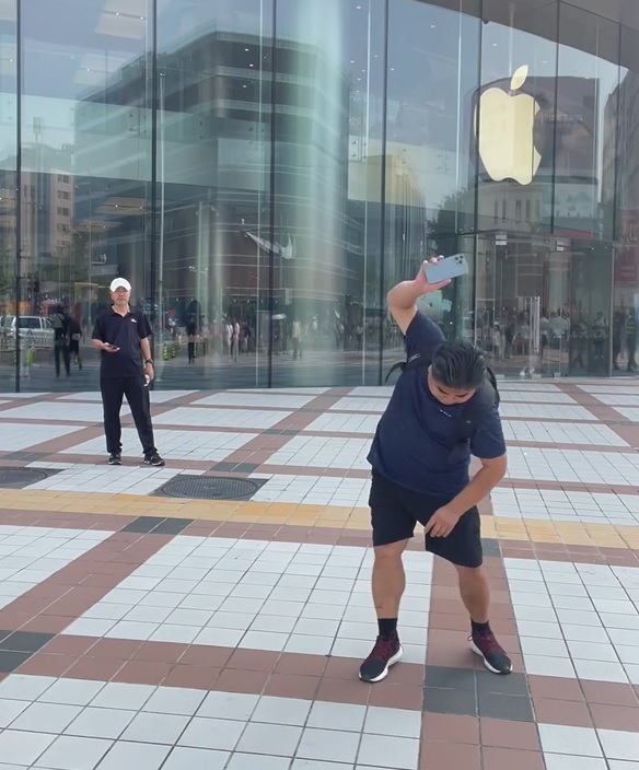 劉金在蘋果店外反覆把其iPhone擲落地。影片截圖