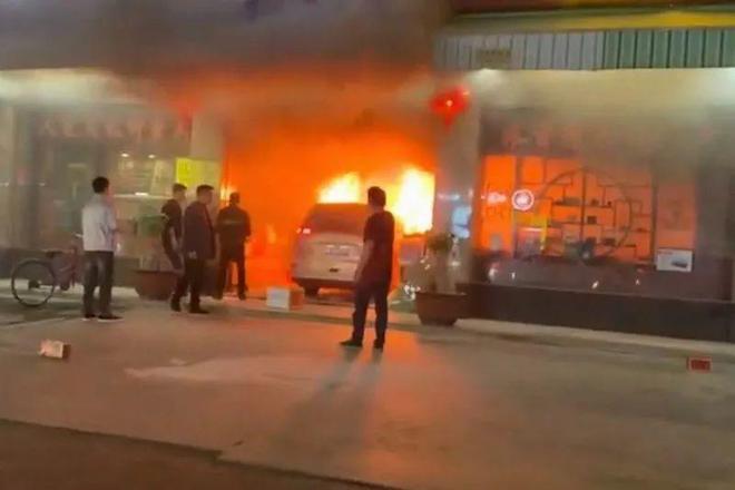 白色私家车撞入商店后迅即引发大火，周边商店人员欲救无从。影片截图