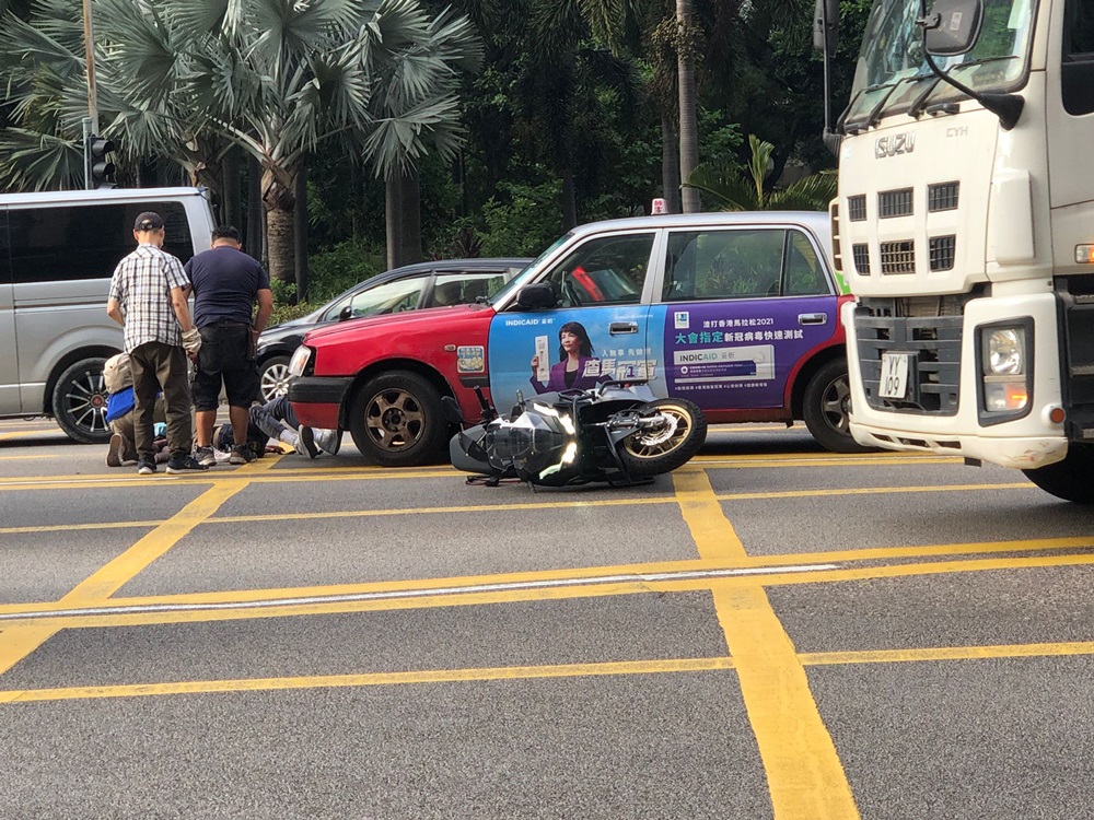 有途人協助將電車車司機從的士車底拉出。
