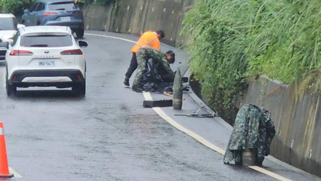 台灣軍方將跌出卡車的8吋榴彈回收。中時
