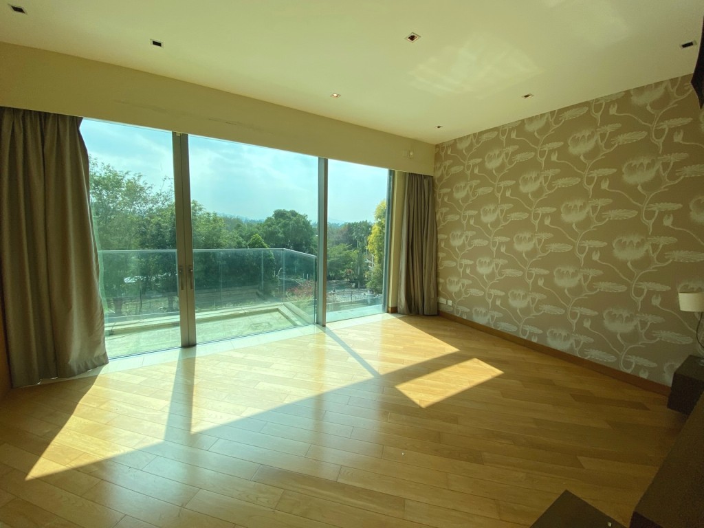 主人房空间偌大，落地玻璃门连露台，把翠绿景致映入室内。