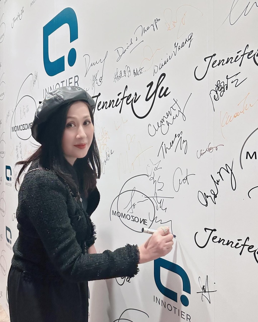 江欣燕在布景板挥笔签名。