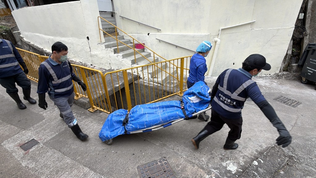 仵工將遺體移送殮房。