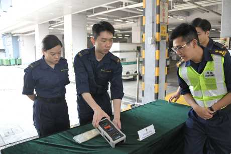 海关署理高级督察陈杰论(右)展示检查分辨爆炸品的拉曼光谱仪。 黄伟强摄