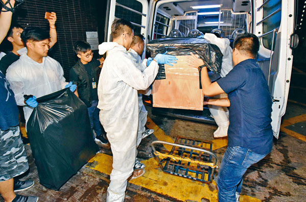 警员在张祺忠的办公室搬走用作藏尸的旅行箧及木箱。
