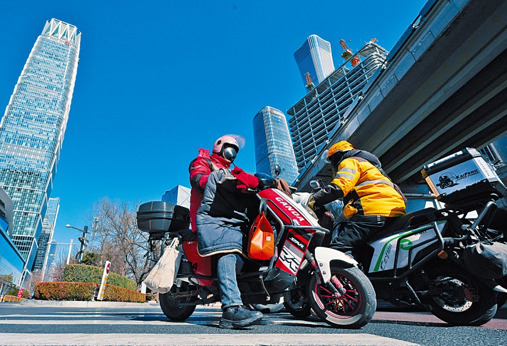 京東（左）和美團（右）的兩名外賣騎手正在送餐中。