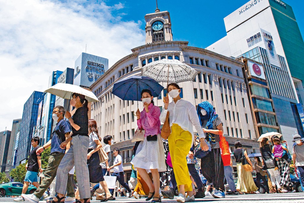 東京天氣炎熱，途經銀座區的民眾紛紛撐傘遮太陽。