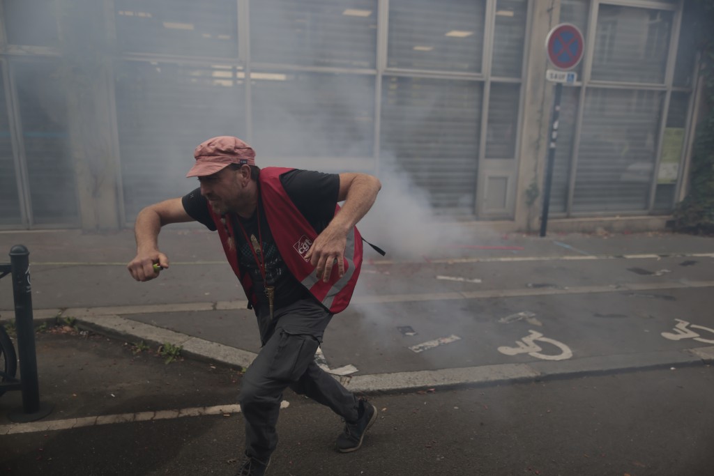 在法国西部南特举行的示威活动中，一名抗议者在警察发射催泪弹时逃跑。AP