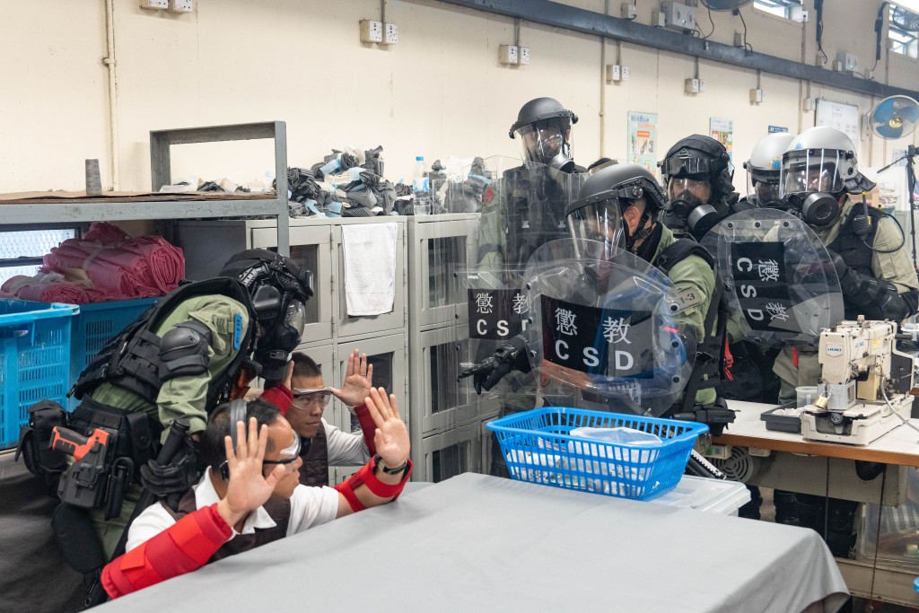 懲教緊急應變隊及區域應變隊人員模擬攻入院所內的工場,制服違紀在囚人士。 懲教緊急應變隊及區域應變隊人員模擬攻入院所內的工場,制服違紀在囚人士。