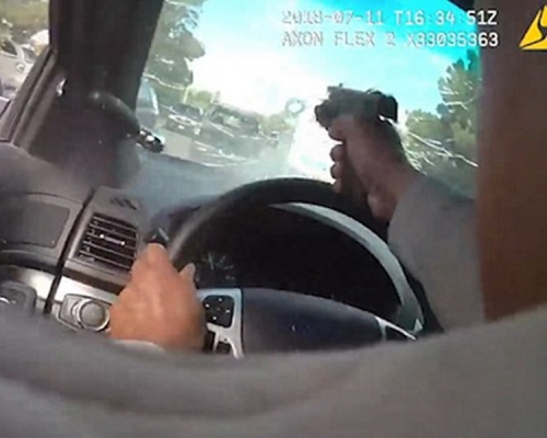 警員開槍射穿汽車的擋風玻璃,擊斃前車內的一名疑犯。片段截圖