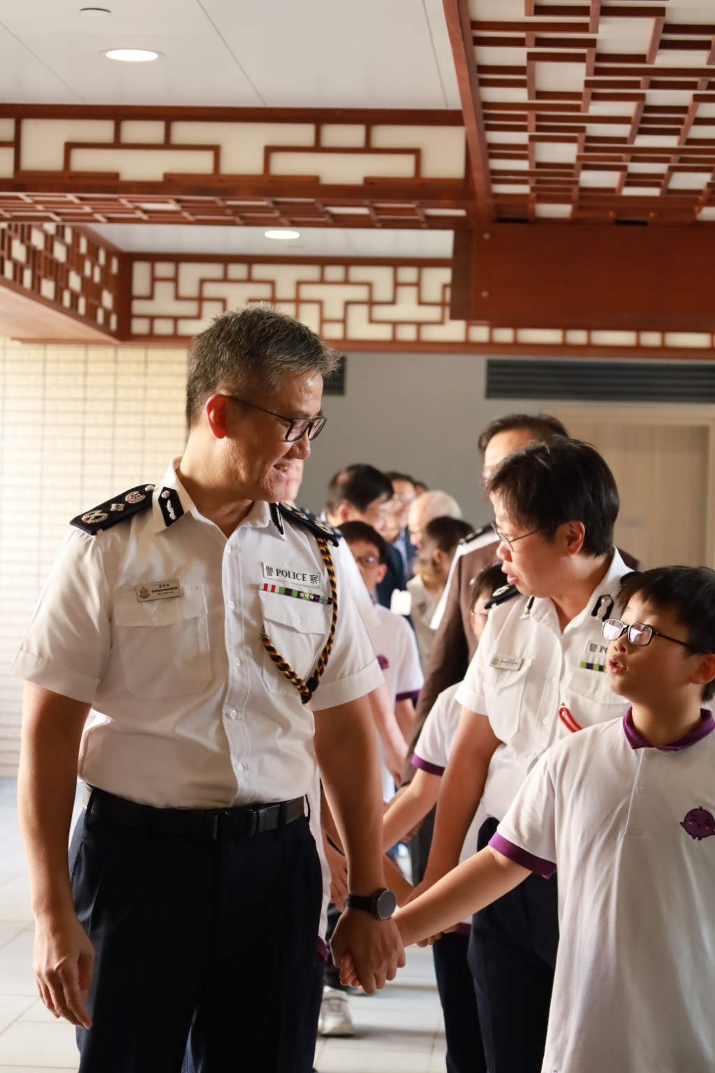 警務處處長蕭澤頤（左一）在典禮開始時與提子大使一同進入會場。