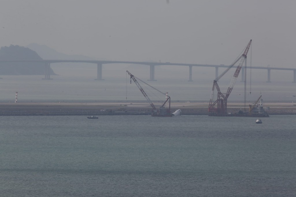 打撈船吊起被撞落海的機管局巡邏車。 打撈船吊起被撞落海的機管局巡邏車。