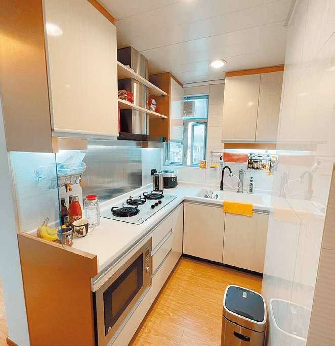 長形廚房以淺色為主調，備有上下列廚櫃。