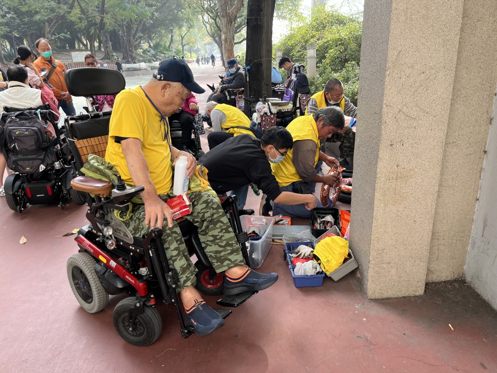 麦Sir与另一名「四个辘」技工华叔(黄衫)，一同加入工作小队为同路者维修电动轮椅。(受访者提供)