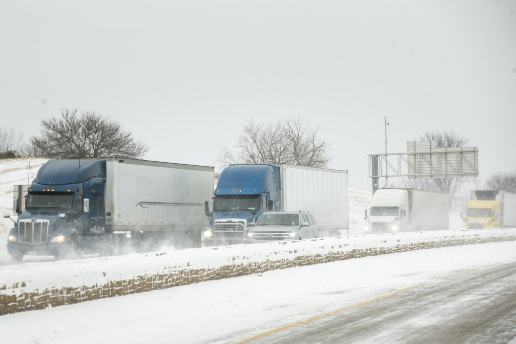 在爱荷华州科拉尔维尔，货车受暴雪天气影响被困在公路上。AP