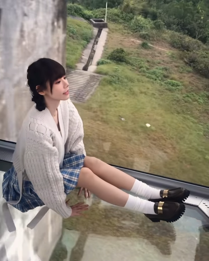 林明禎穿短裙坐在玻璃欖車。