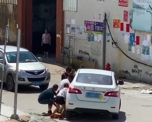 江門一名騎電動車的男子被捲入車底,十多名路人合力抬車救人。 影片截圖