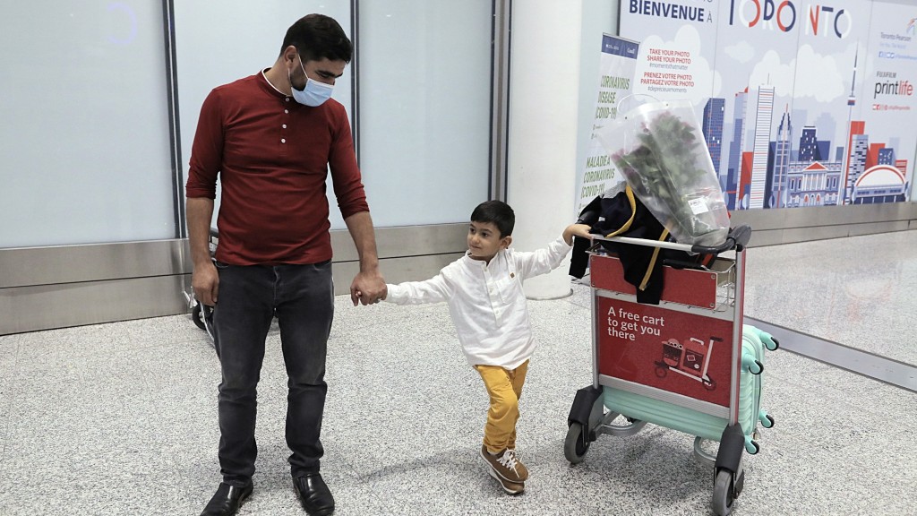 一名取得加拿大永居身份的阿富汗男子在多倫多接3歲的兒子入境。 路透社