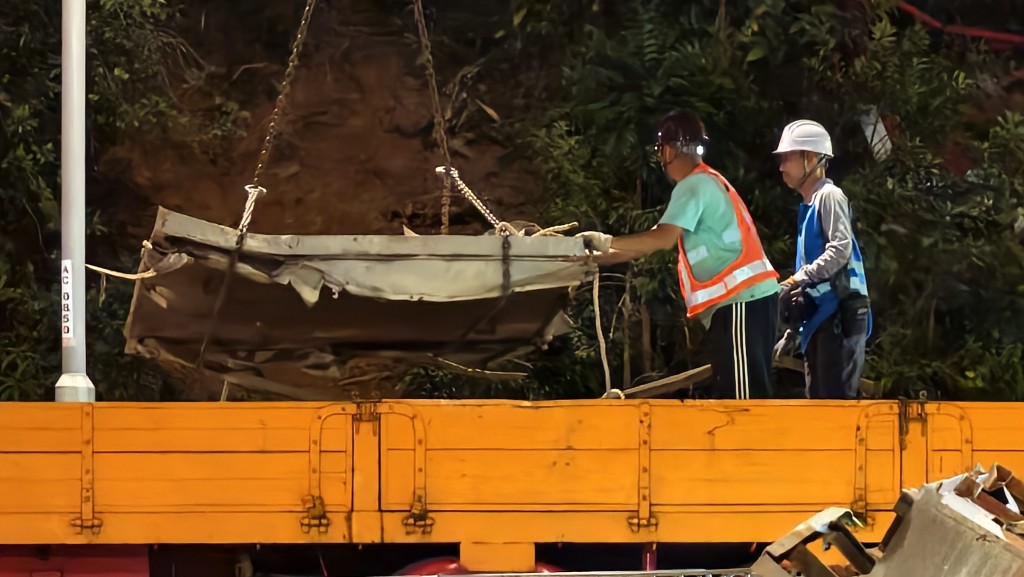 工人將金屬殘骸吊走。黃文威攝