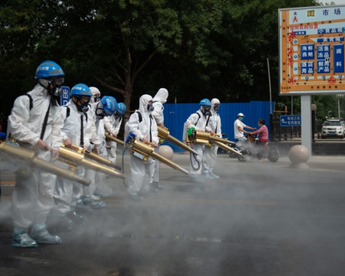 北京藍天救援隊隊員在岳各莊批發市場展開消毒工作。(新華社圖片)