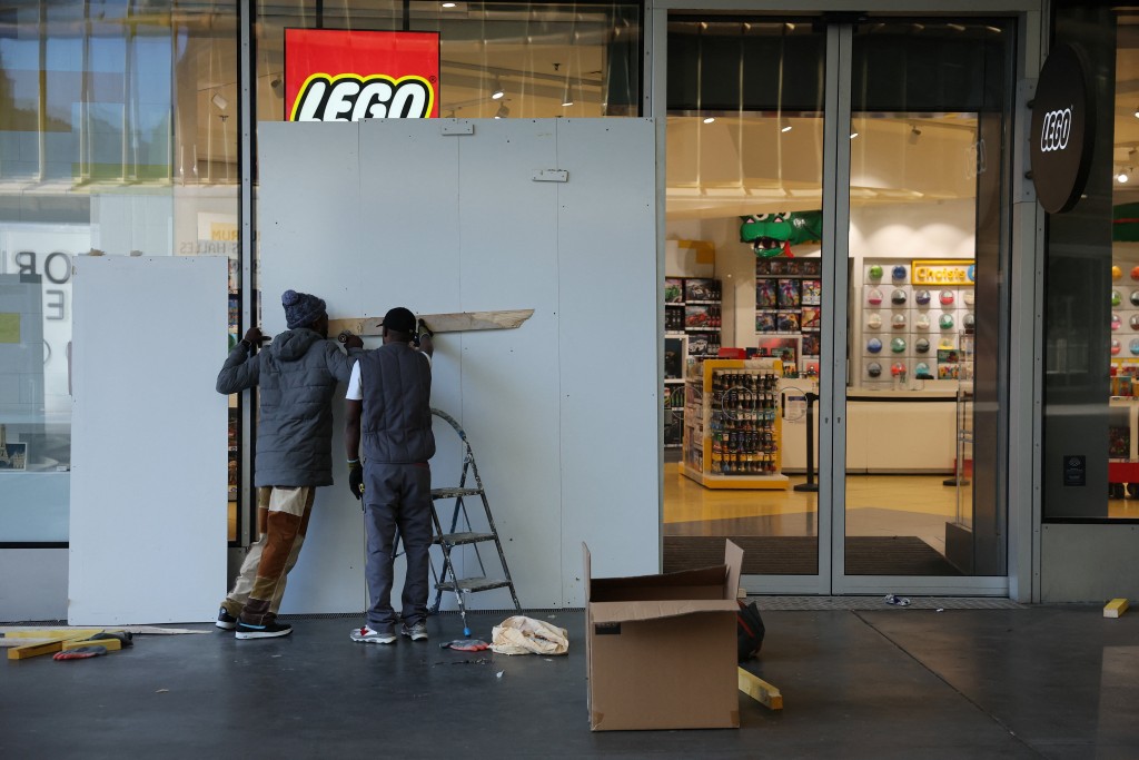 有商店以木板围起，防止被人破坏。路透社