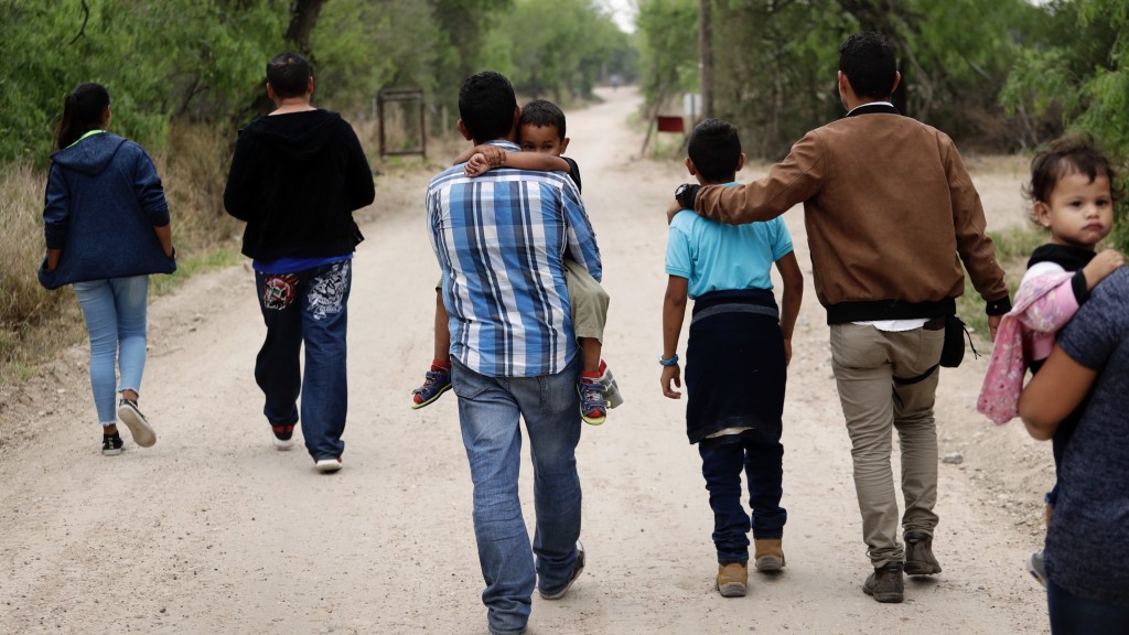 难民家庭从格兰德河上岸后步行。 美联社