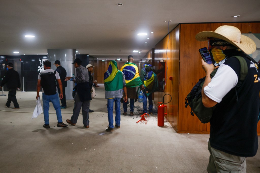 巴西示威者身披国旗闯总统府大肆破坏。路透社
