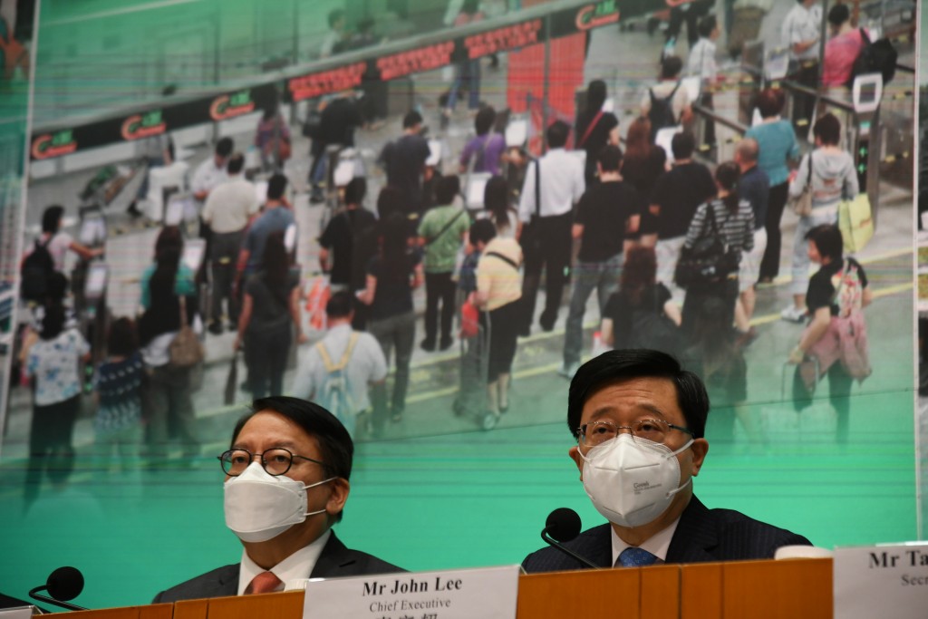 李家超（右）宣布香港与内地2月6日全面通关。何健勇摄
