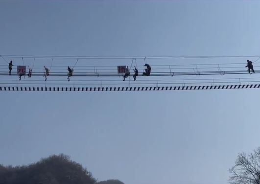 龍潭大峽谷景區有遊客在玩網紅鐵索橋時，意外跌出，在半空吊吊揈。影片截圖