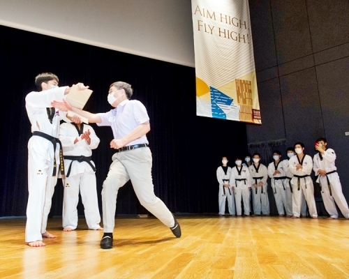 郭位校長昨獲參與演出的城大跆拳道校隊臨時邀請上台，表演手刀劈木板。