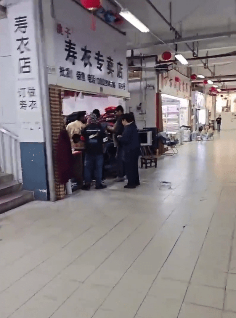 網上影片顯示,數名外國人擠滿在壽衣店門外。 網上影片顯示,數名外國人擠滿在壽衣店門外。