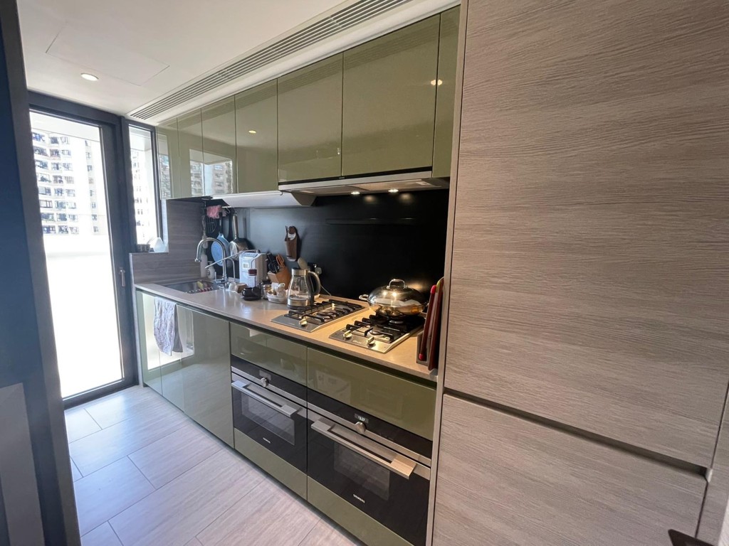 厨房厨柜以浅绿色设计，外连工作平台。