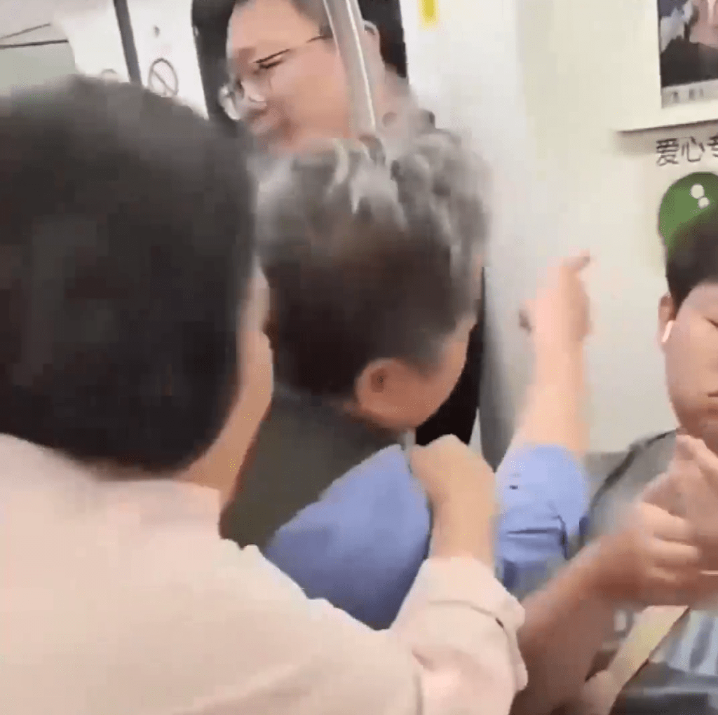 老翁指著男乘客身後的「愛心專座」標誌。 老翁指著男乘客身後的「愛心專座」標誌。