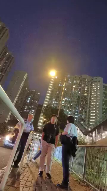 少年身穿黑衫、颈挂相机，单手插在裤袋不发一言。香港突发事故报料区及讨论区FB