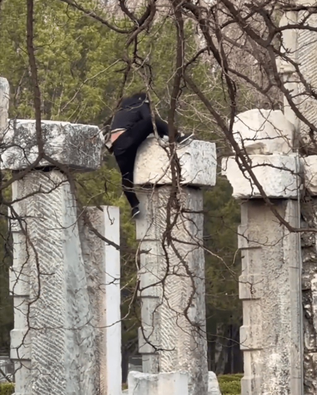 男子在攀爬遺址建築，有驚無險。