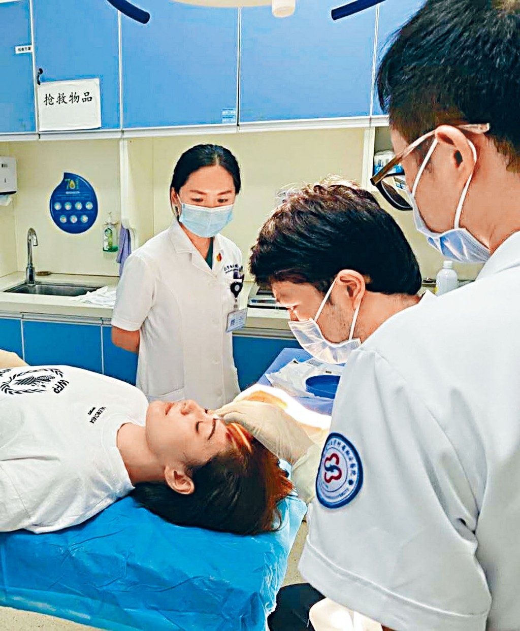 阿娇躺在病床上让医生检查伤口。