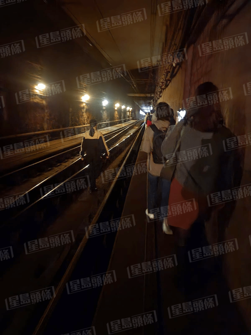 乘客摸黑沿路軌步行返月台。
