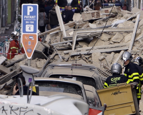 救援人員在瓦礫中搜救疑被活埋居民及路人。AP