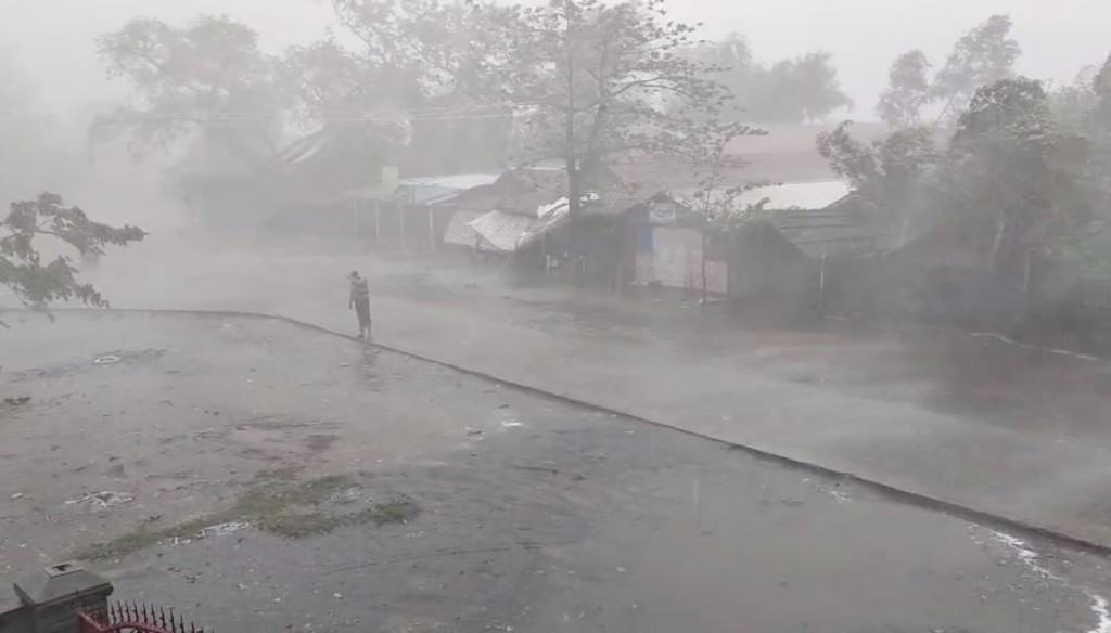 缅甸实兑市一名男子冒着狂风暴雨在街上前进。 路透社