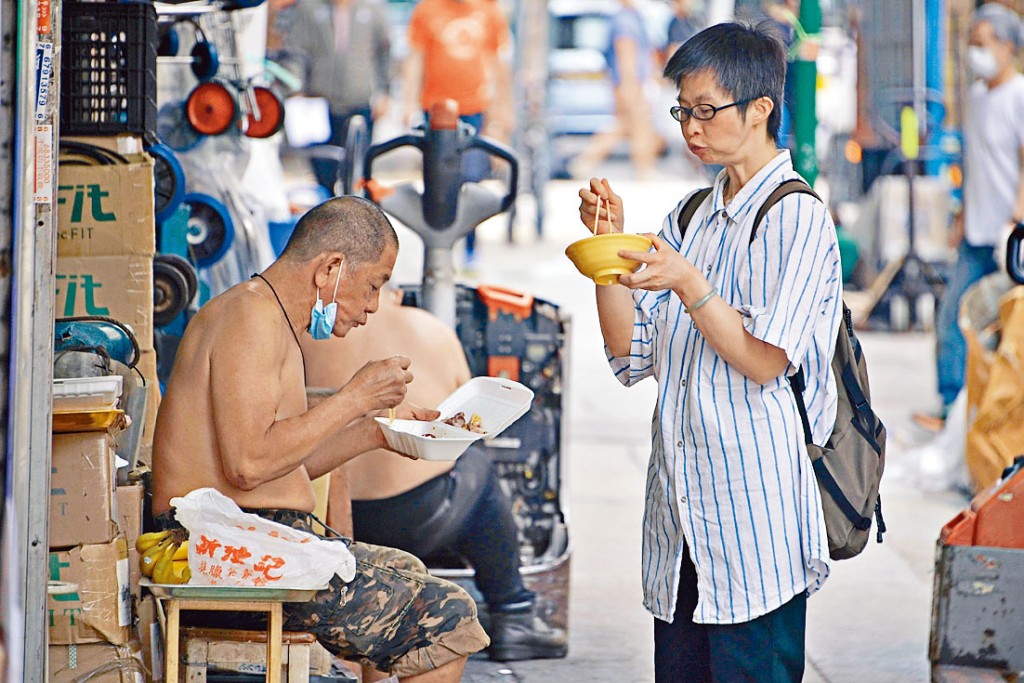 防疫政策下,市民「搵食」艱難,在街頭除罩用餐。