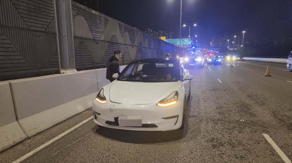白色Tesla收掣不及，撞到電單車。圖為Tesla男司機和女乘客。黎志偉攝